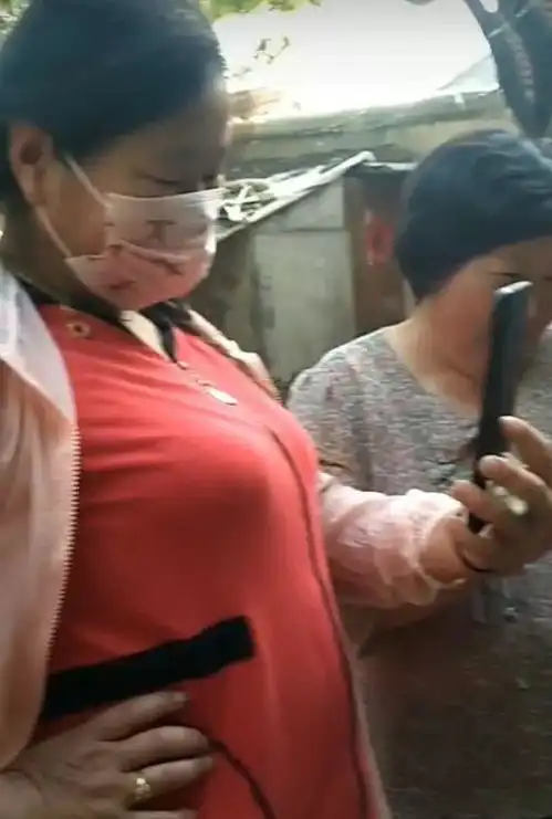 大衣嫂开心时配合乡邻拍照自拍,不开心挥手撵乡邻的样子真逗