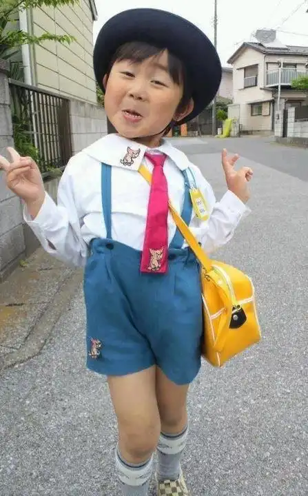 搞笑图片一个戴着黄帽子的穿校服小孩表情特别欠手举成耶的形状文字好像是终于放学了
