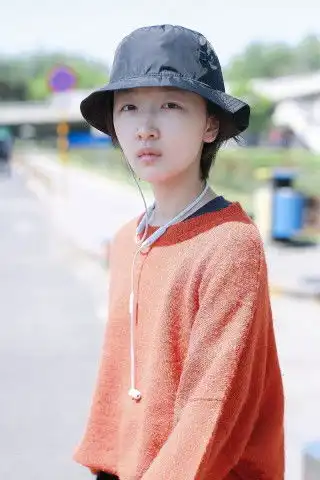 周冬雨以文艺造型出行,穿上橘色针织衫搭阔腿裤,休闲时髦
