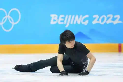 羽生结弦摔倒在地,闭眼皱眉表情痛苦,身上沾满冰渣,沮丧摘手套